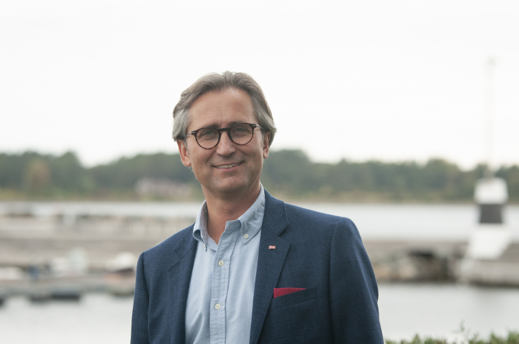 mann i dress foran sjøen