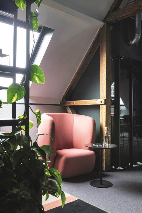 Kontormiljø med grønne vegger og rød stol