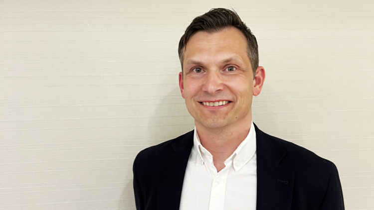 mann i dress mot gul murvegg