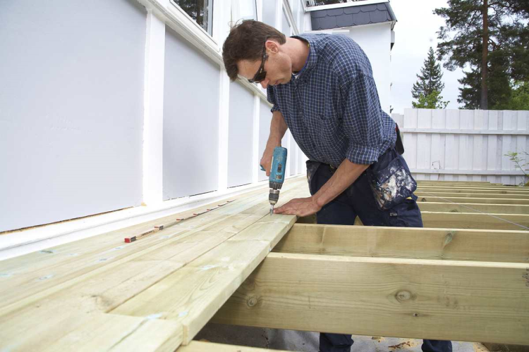 Mann snekrer terrasse