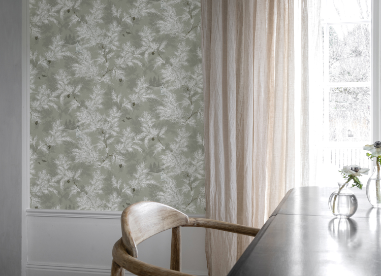 rom med kontorstol, pult, vindu med ferskenfarget gardin og et grønt tapet på veggen 