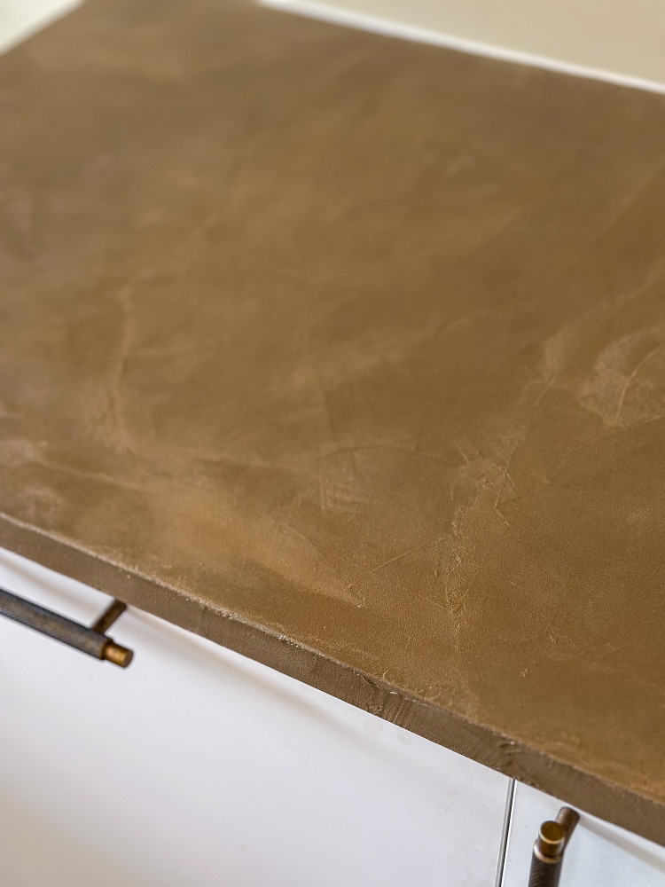 brun kjøkkenbenk over hvite skap. benkeplate i mikrosement.