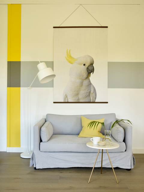 Stue med grå sofa og gul dekor