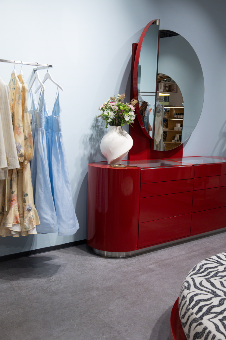 rød kommode mot lyseblå vegg, klesstativ ved siden av 