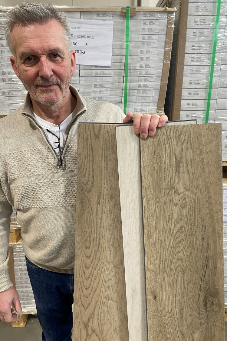 mann holder frem gulvbord, klikkvinyl