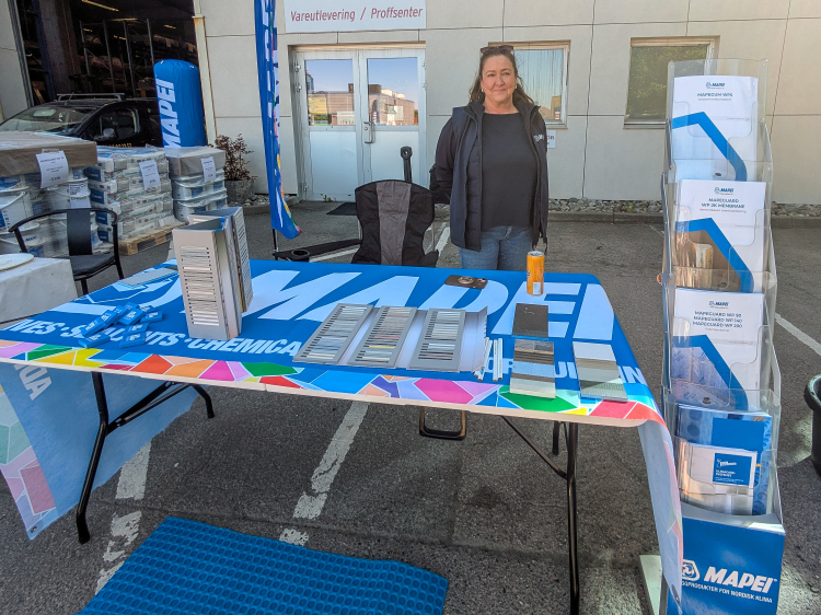 Dame ved Mapei-stand på uteområdet til Norfloor på Alnabru