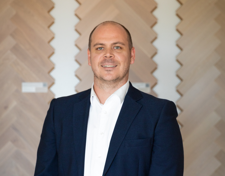 mann i dress med parkett i bakgrunnene