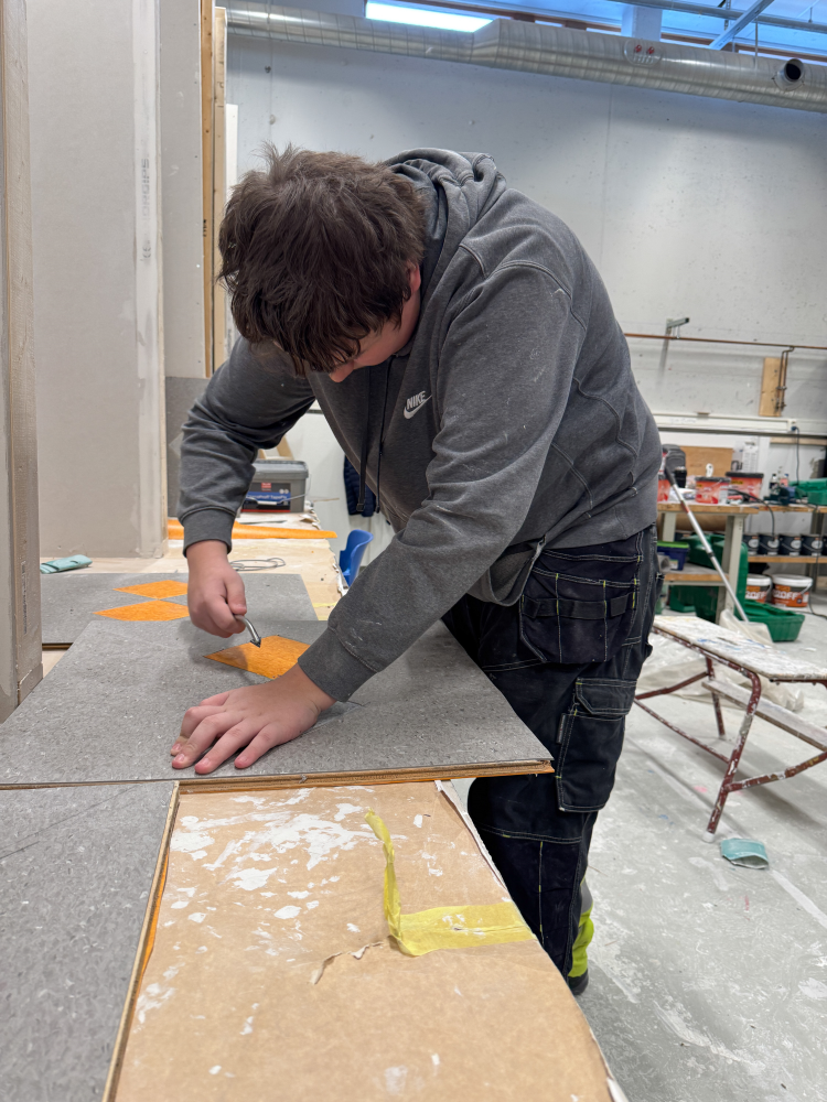 Elev fra Stovner VGS som jobber med linoleumsgulv