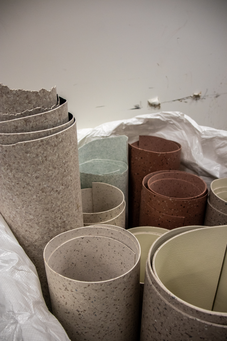 ruller med avkappet gulvbelegg stikker opp av en storsekk for gulvretur