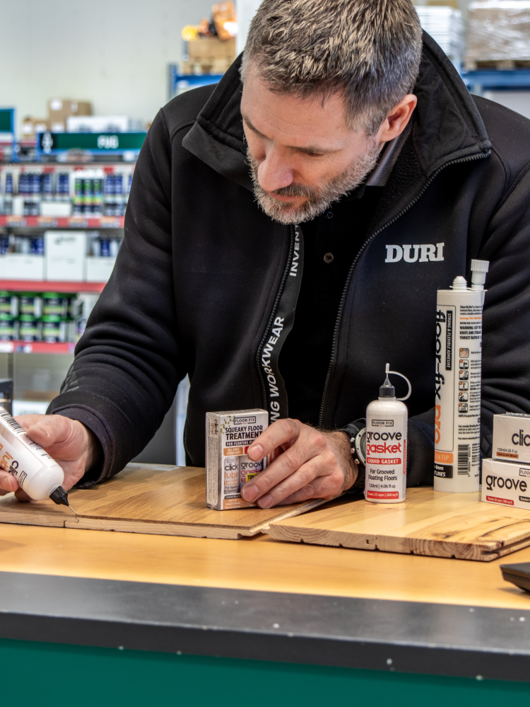 mann smører gulv fra liten tube