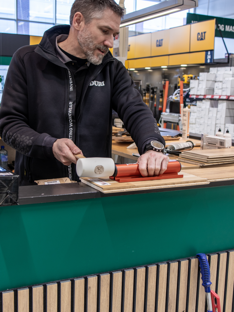 mann med gummihammer banker på en rød sak