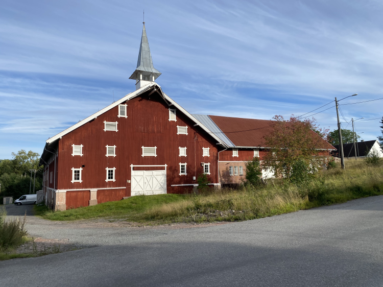 Gårdstun med rød låve.