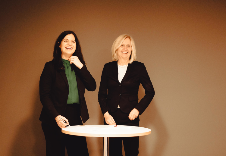 to damer ved et rundt bord