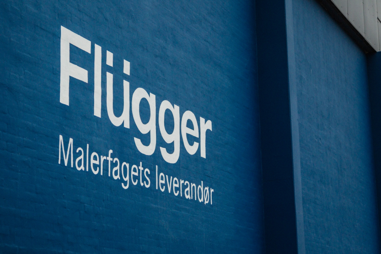 Bilde av Flüggers Logo på et banner.