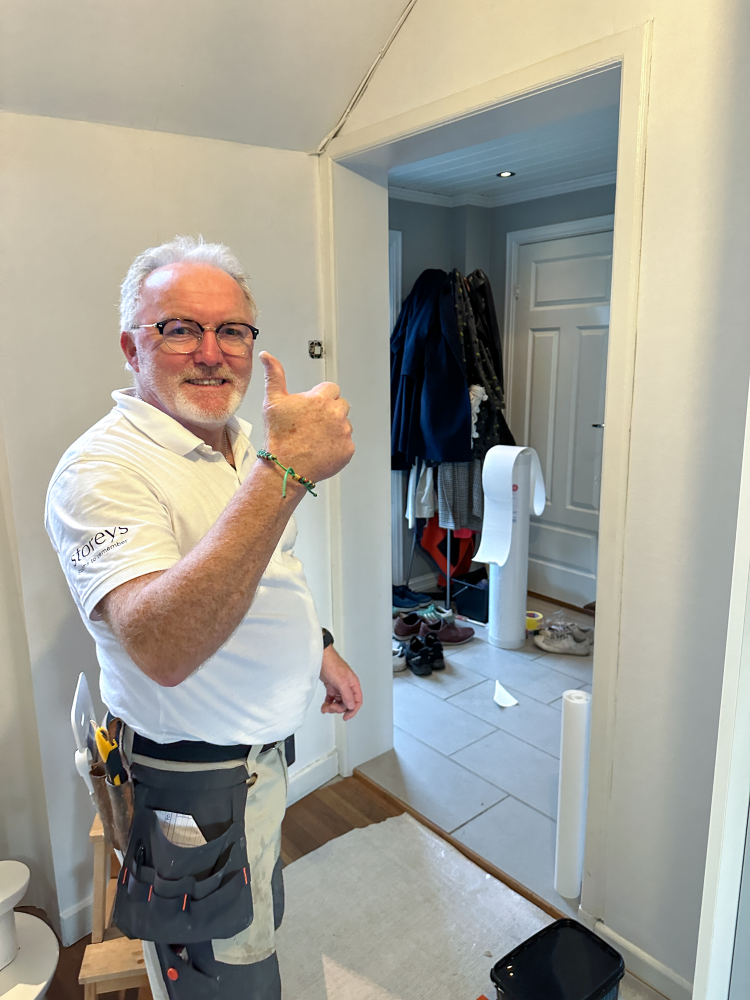 Roar Aune poserer med tommel opp foran vegg som har blitt slettet ut.