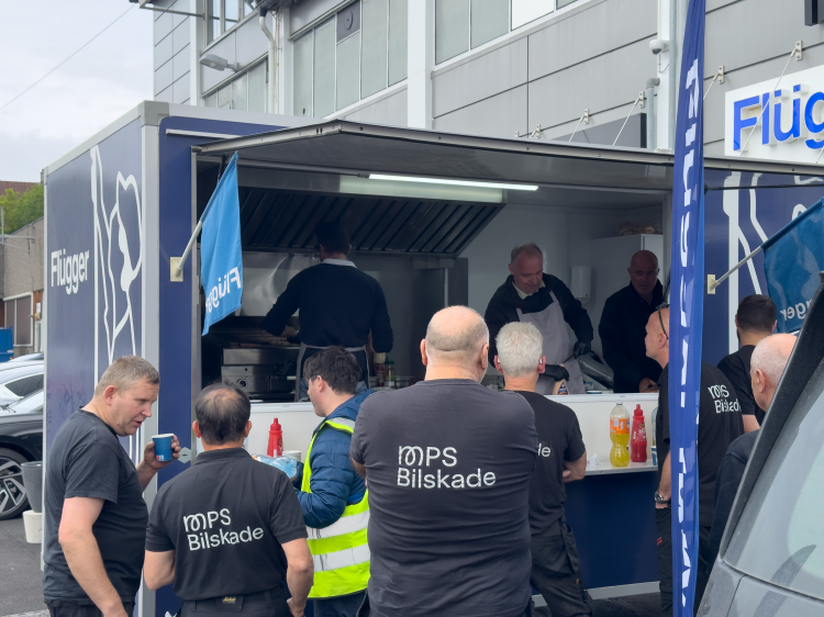 Håndverkere står foran en burgerbod og venter på mat