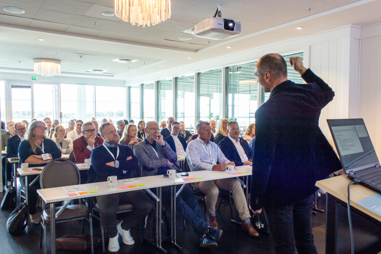 mann foran sittende publikum