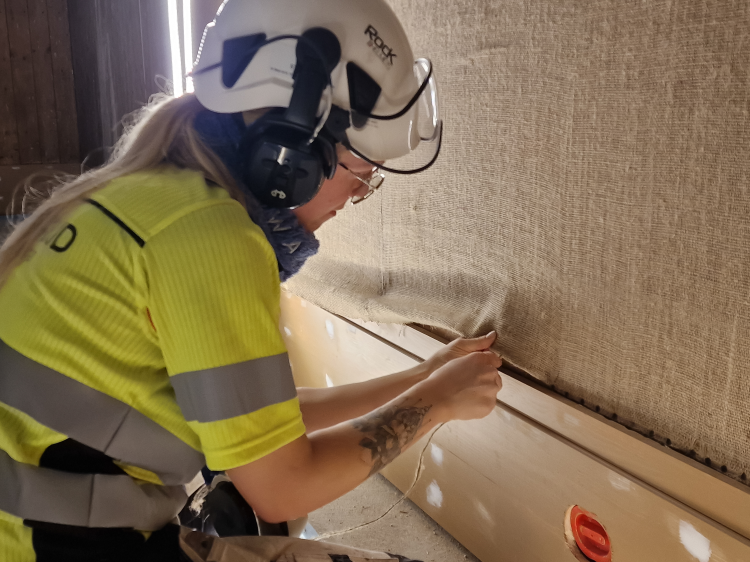 Jutestrie strekkes på veggen.