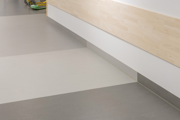 gulv i tre farger i brede striper, oppbrett mot vegg.