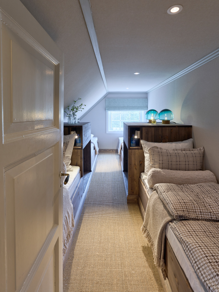 smalt rom, en sovesal, med diskret mønstret tapet på vegg, skråtak og tak