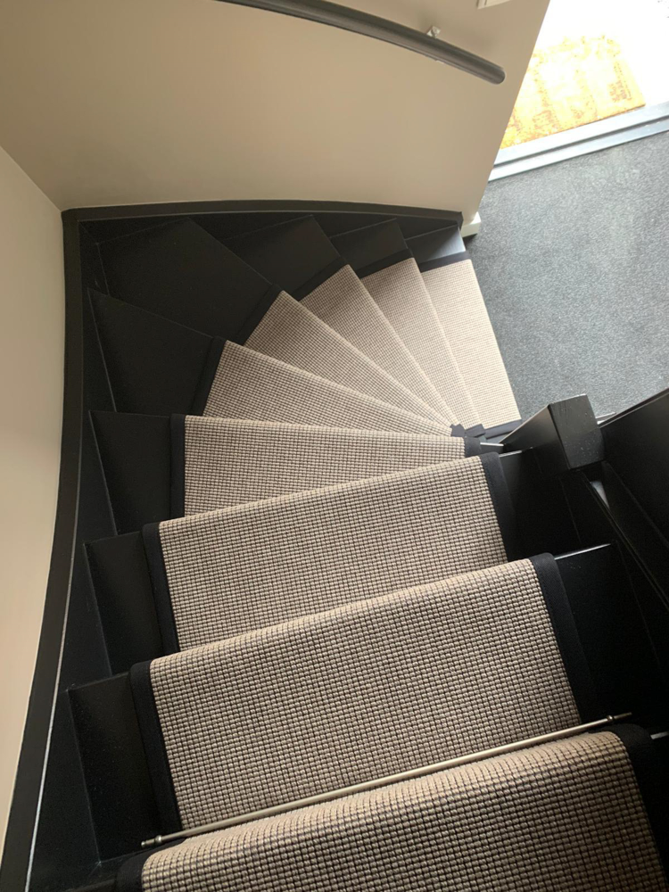 ser nedover en sort tretrapp med en lys teppeløper 