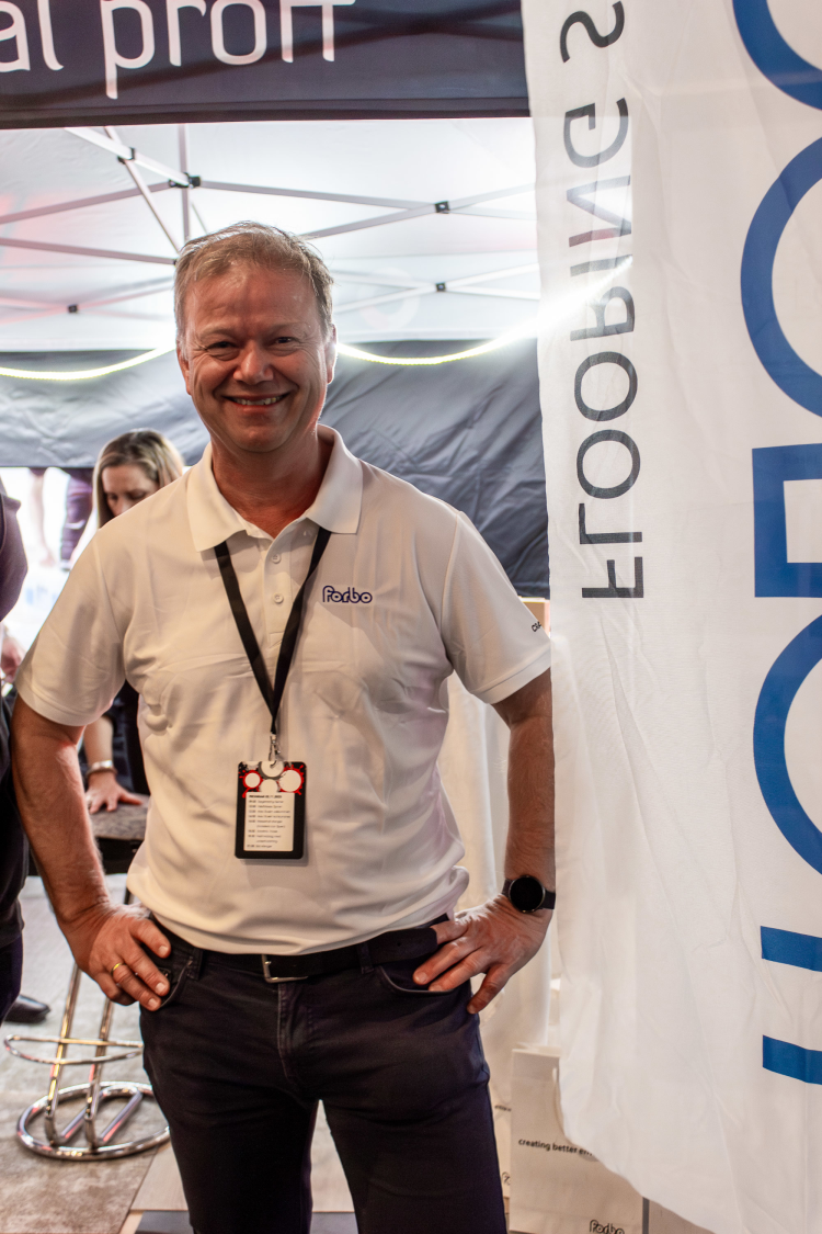 mann i hvit t-shirt foran beachflagg