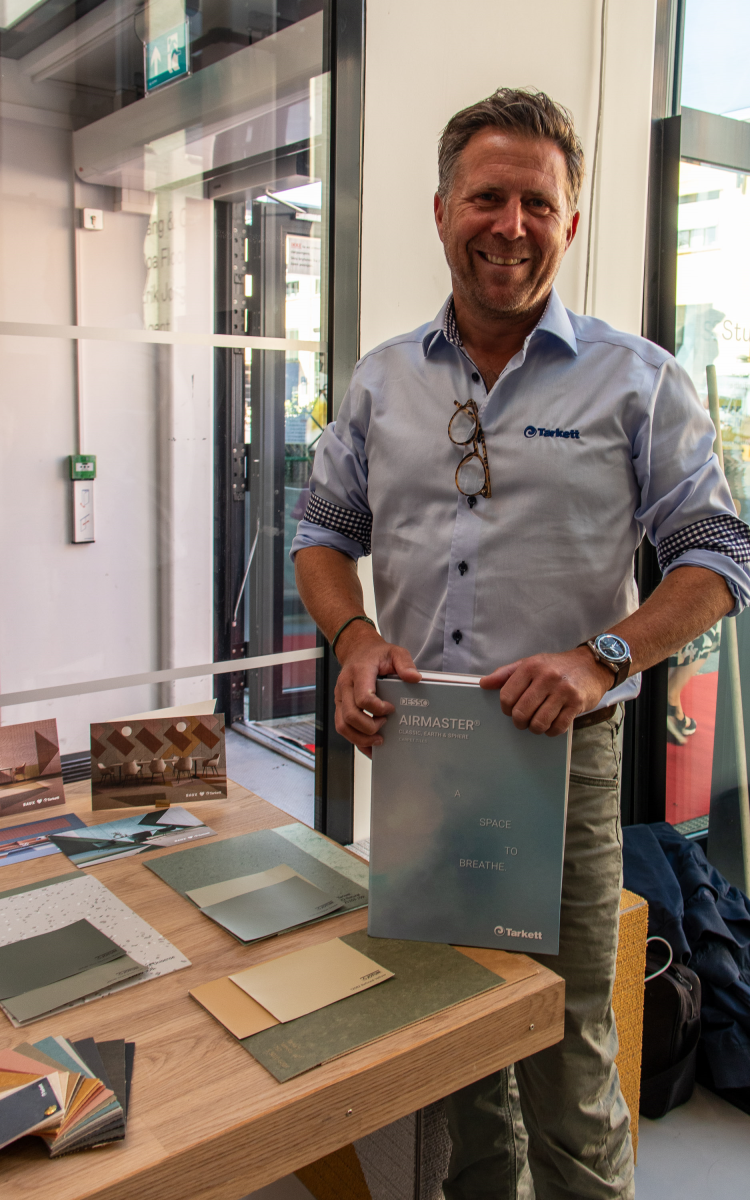 mann ved bord med teppebok i hånden